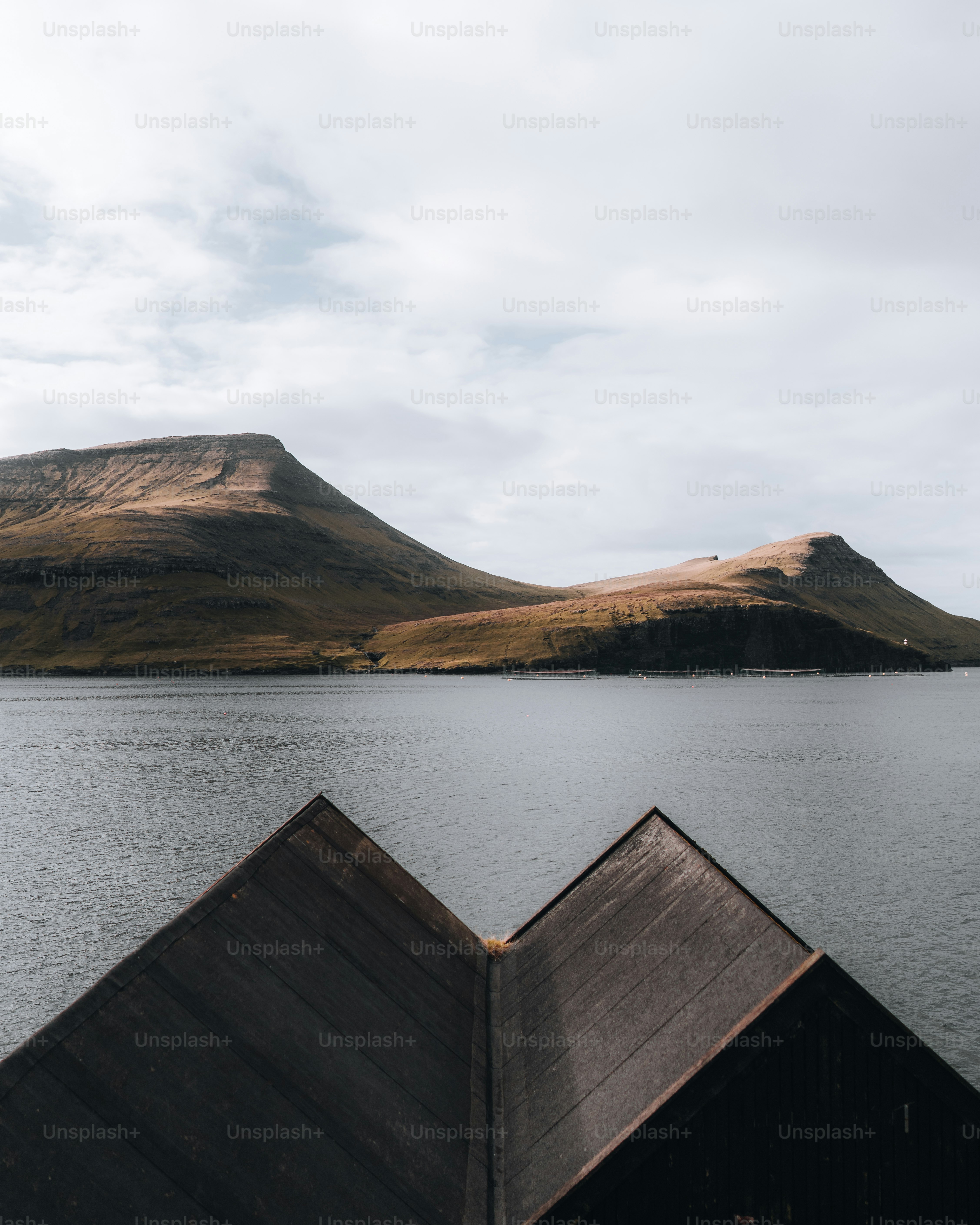 a boat floating on top of a lake next to a mountain