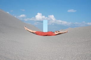 a man laying in the sand with his feet up