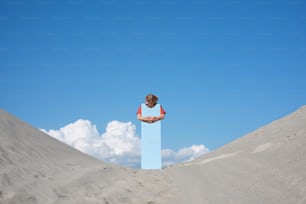 uma pessoa em cima de um bloco azul na areia