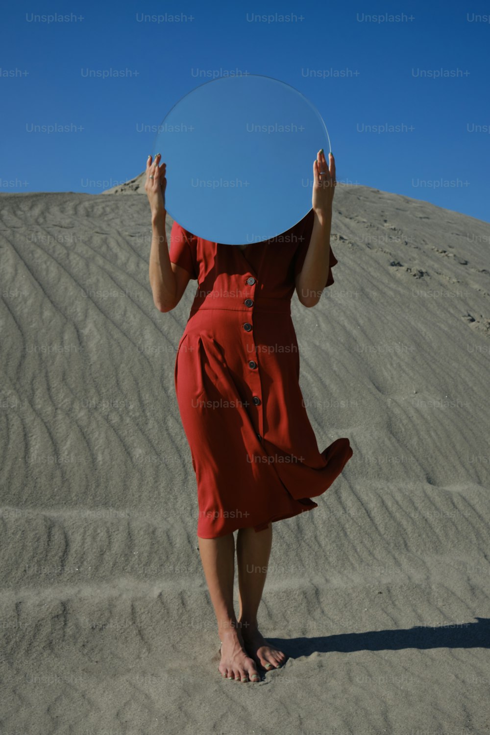 a woman in a red dress holding a frisbee over her head