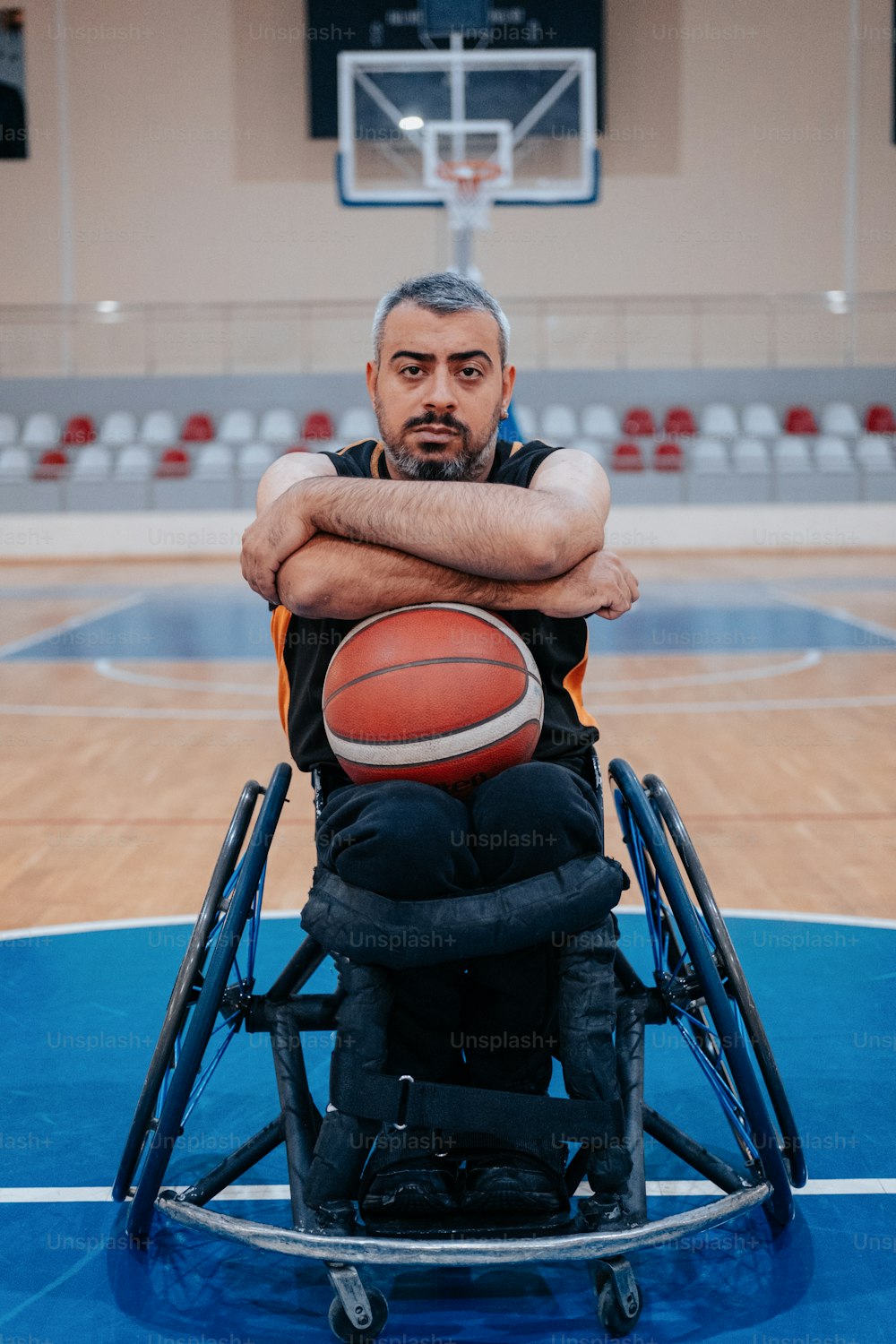 a man in a wheelchair holding a basketball