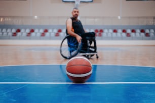 Un homme en fauteuil roulant jouant au basketball sur un terrain
