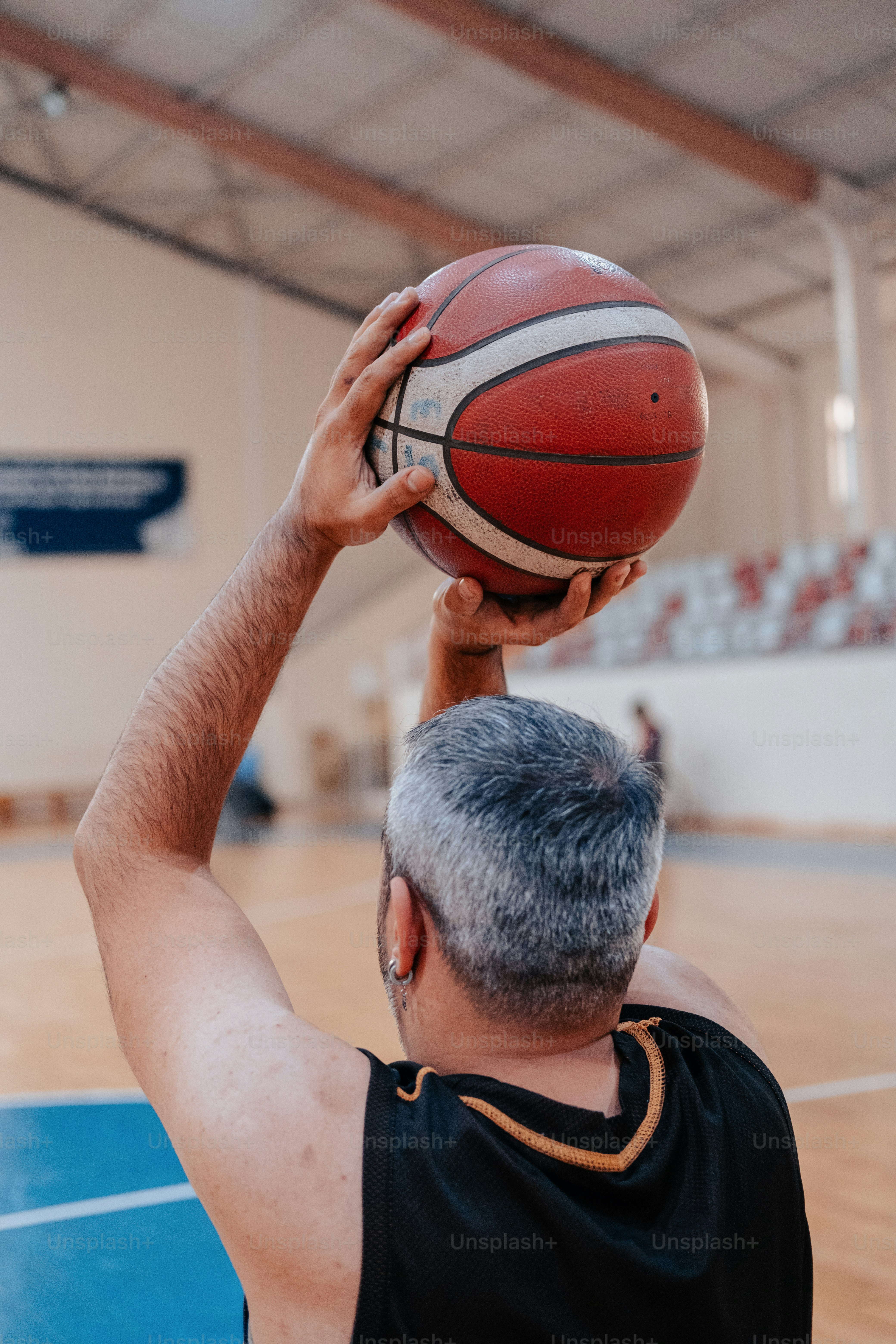 Un hombre sosteniendo una pelota de baloncesto en su cara