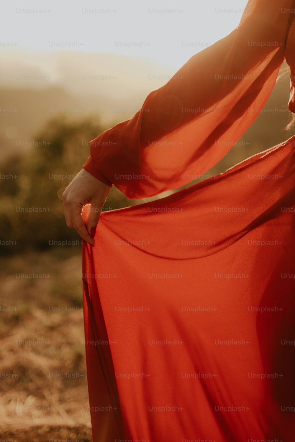 Una mujer con un vestido rojo sostiene su vestido