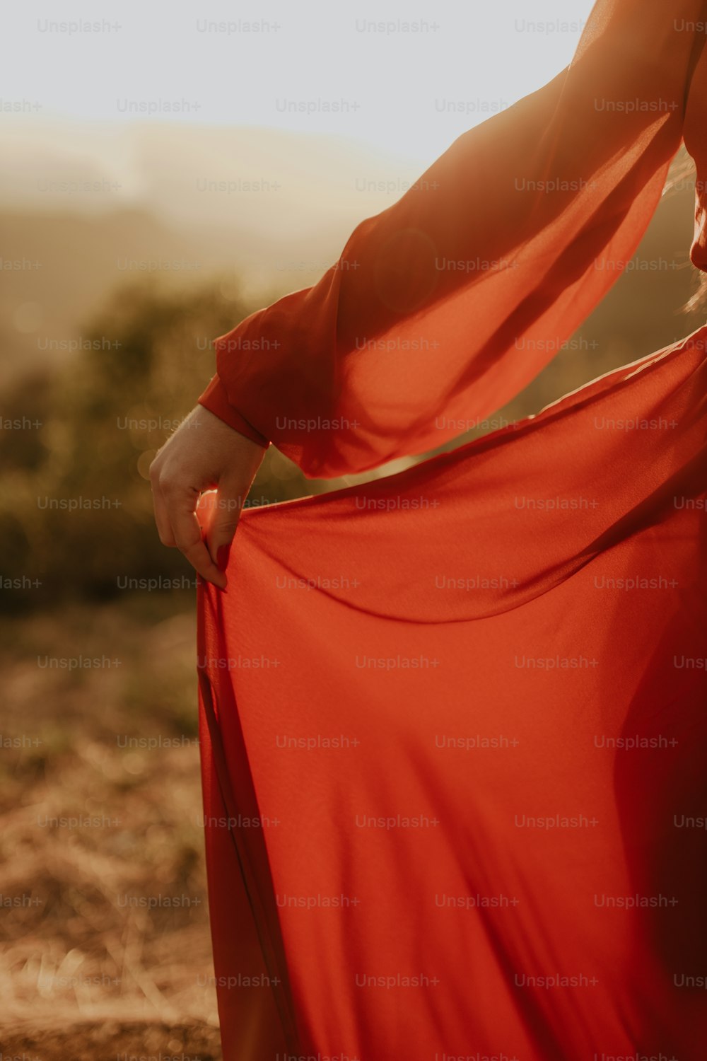 a woman in a red dress is holding her dress