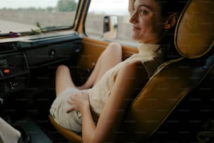 a woman sitting in a car looking out the window