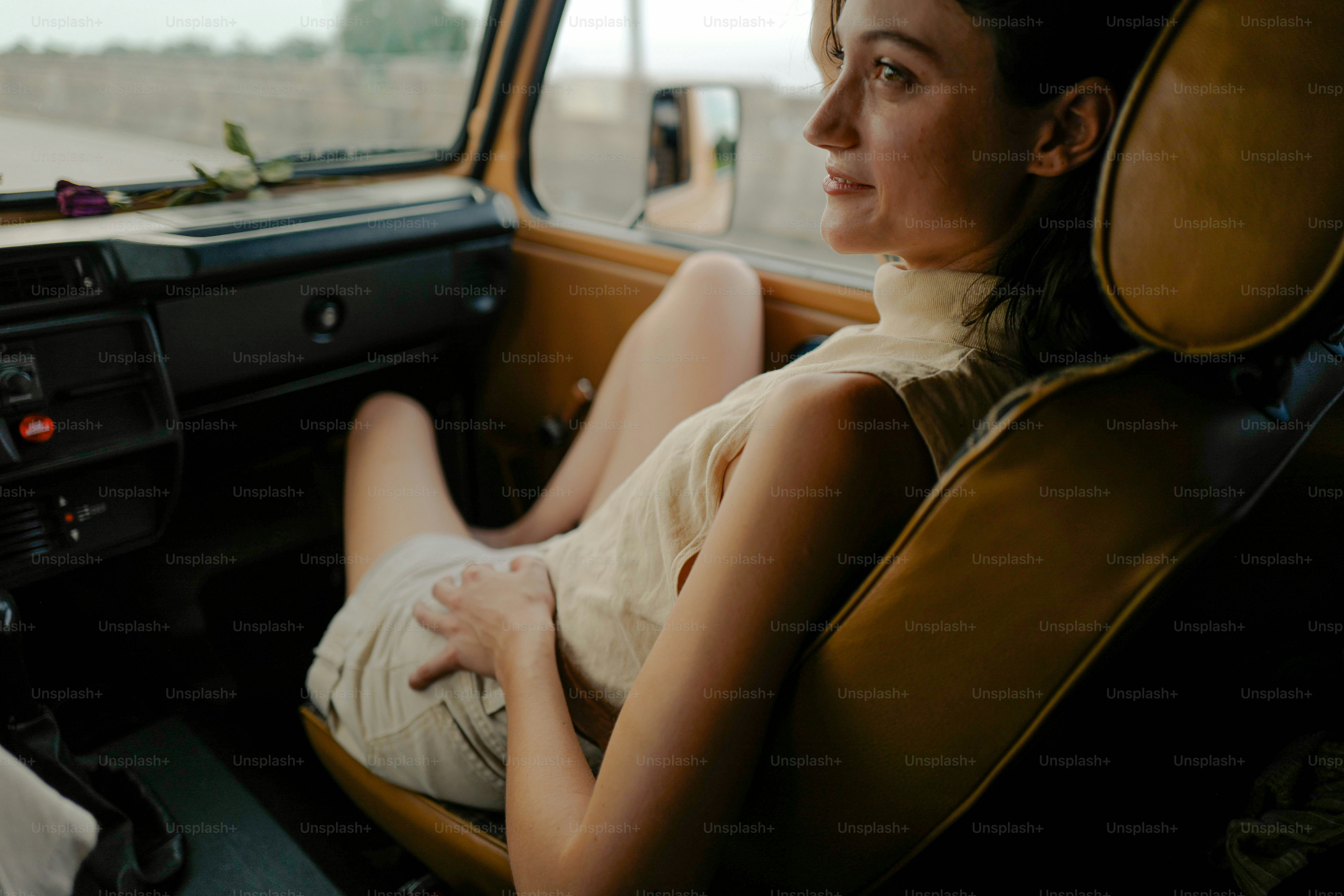 a woman sitting in a car looking out the window