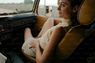 uma mulher sentada em um carro olhando pela janela