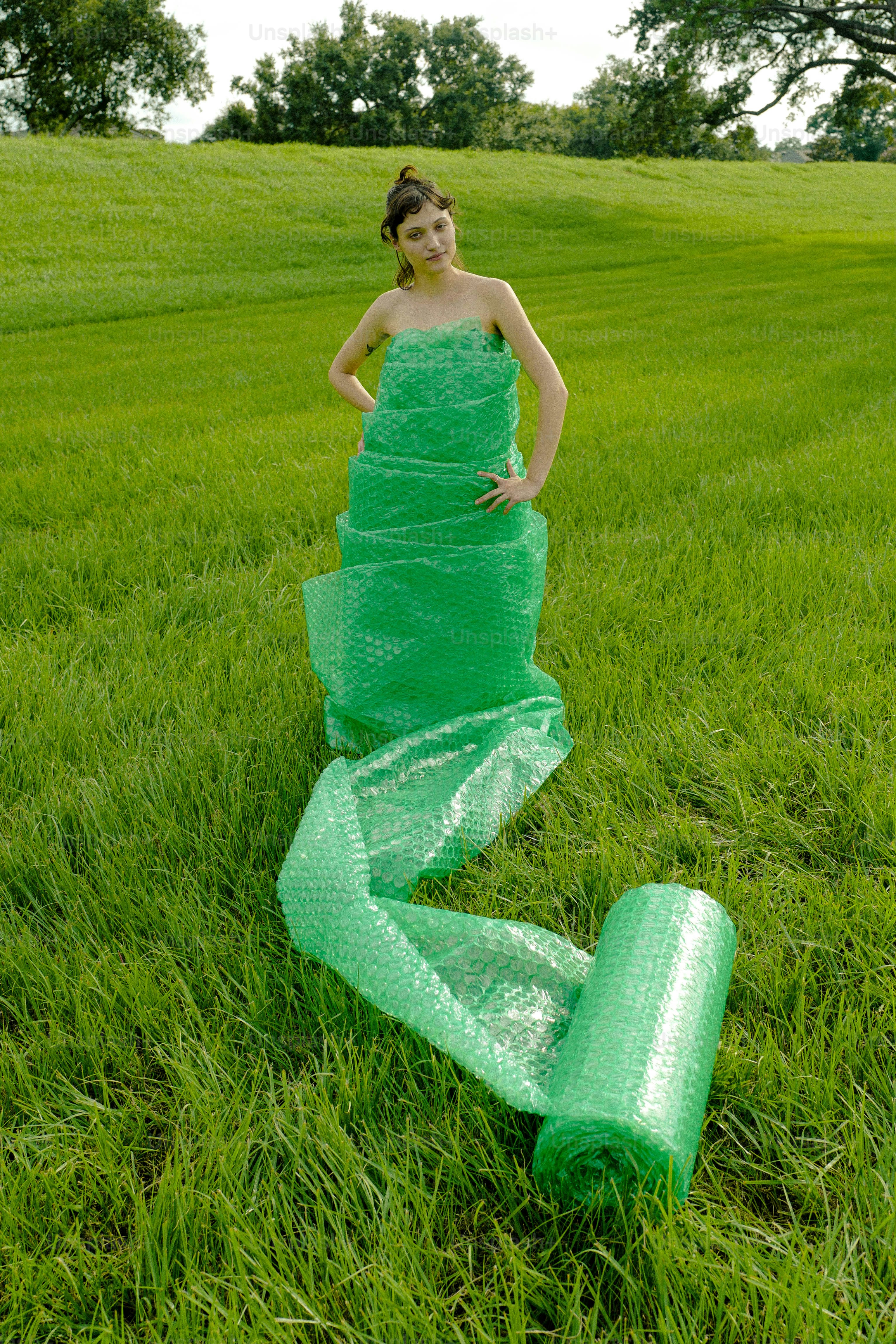 Eine Frau in einem grünen Kleid, die auf einem Feld steht