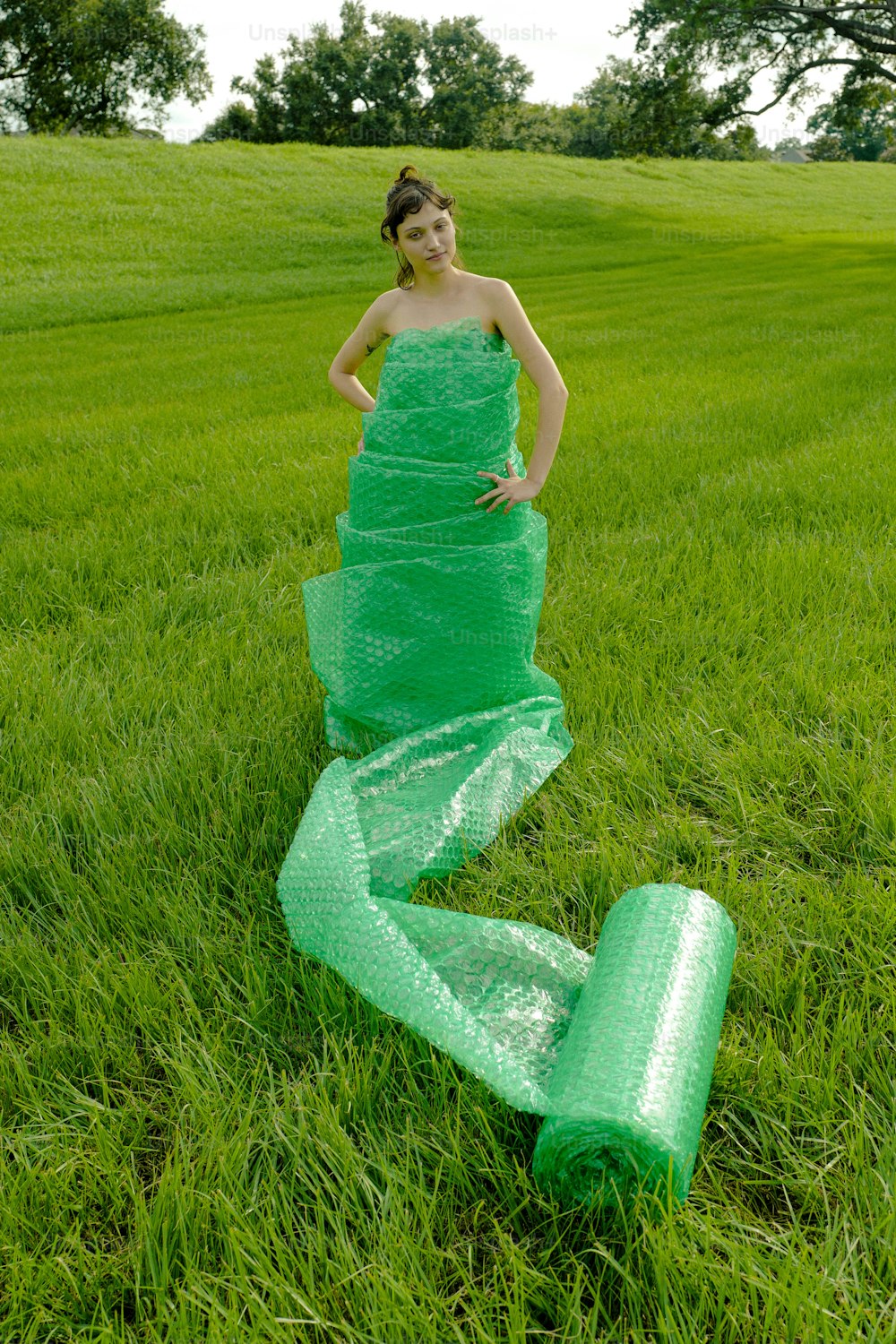 uma mulher em um vestido verde em pé em um campo