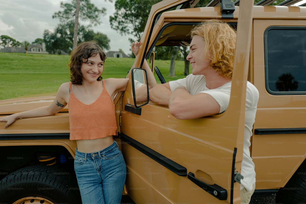 a woman standing next to a man in the back of a truck