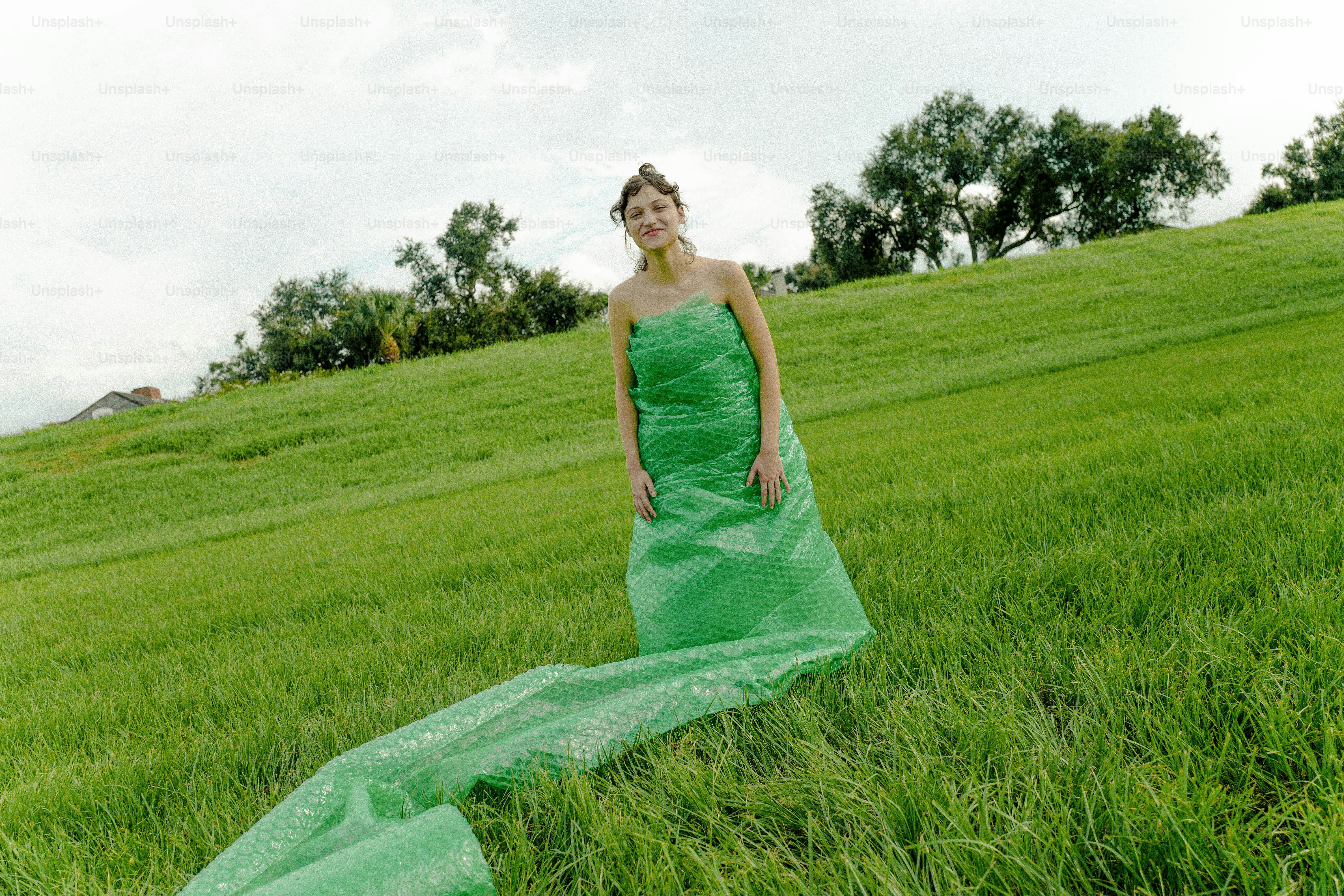 A woman in a green dress standing in a field photo – Dress Image on ...