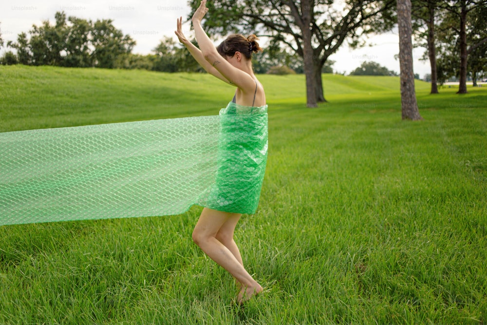 a woman in a green dress is throwing a frisbee