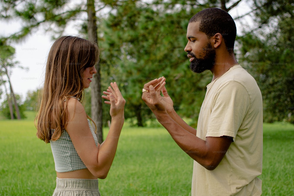 a man standing next to a woman in a field