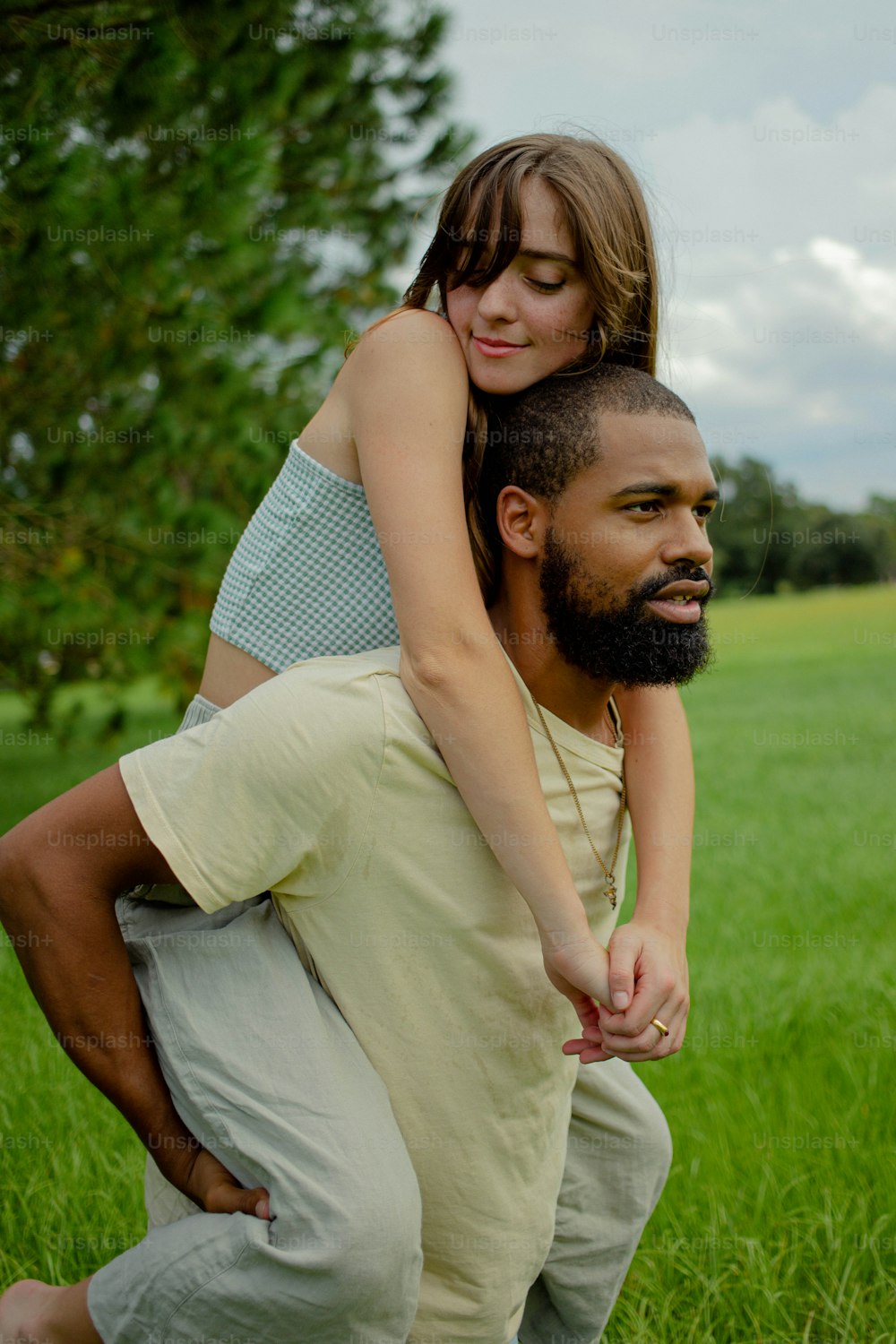 Un hombre sosteniendo a una mujer en su espalda en un campo