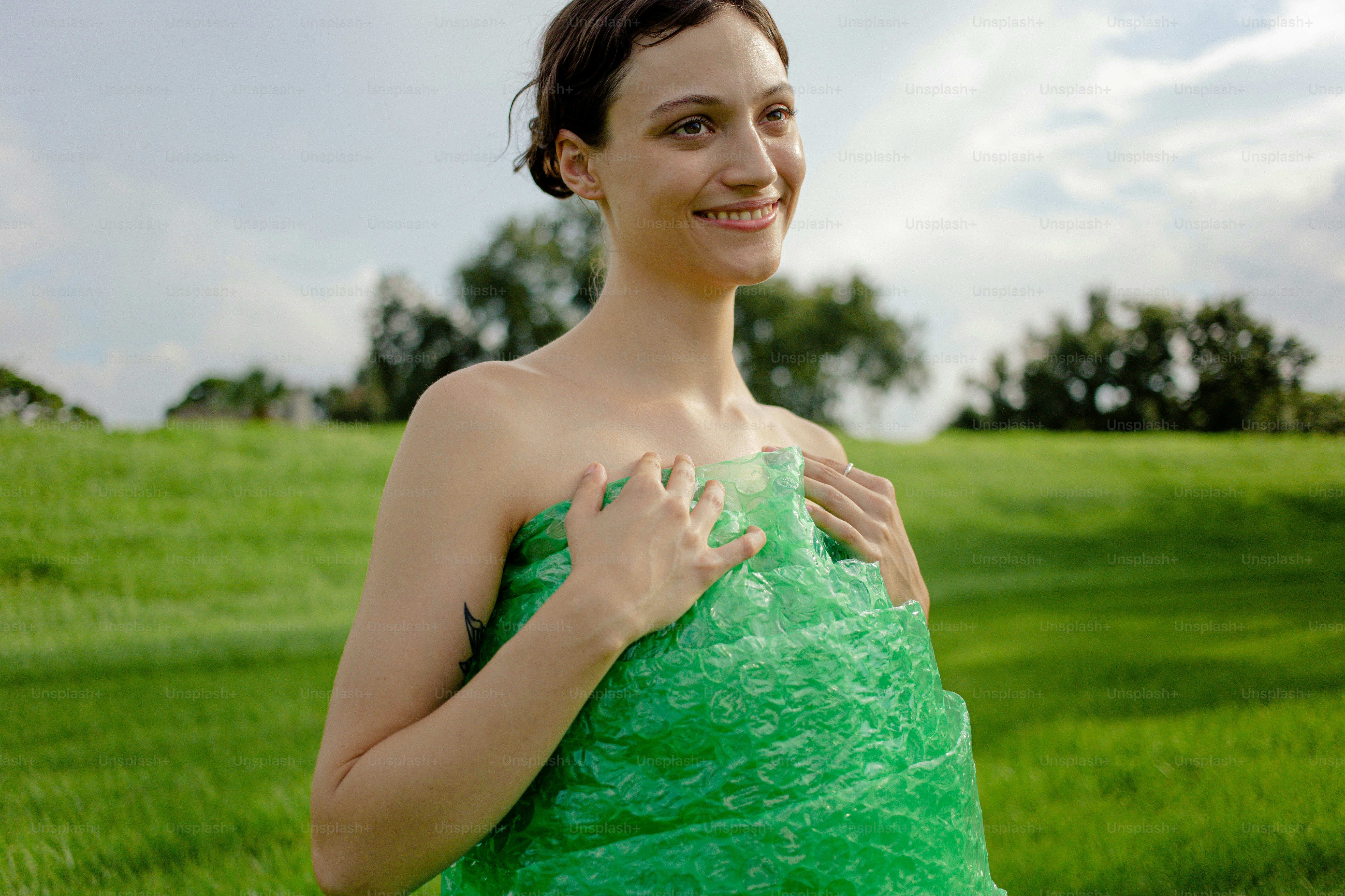 A woman in a green dress standing in a field photo – Female Image on ...