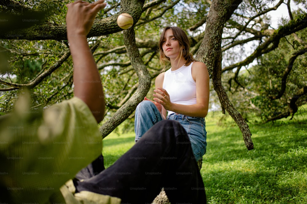 um homem e uma mulher estão sentados debaixo de uma árvore