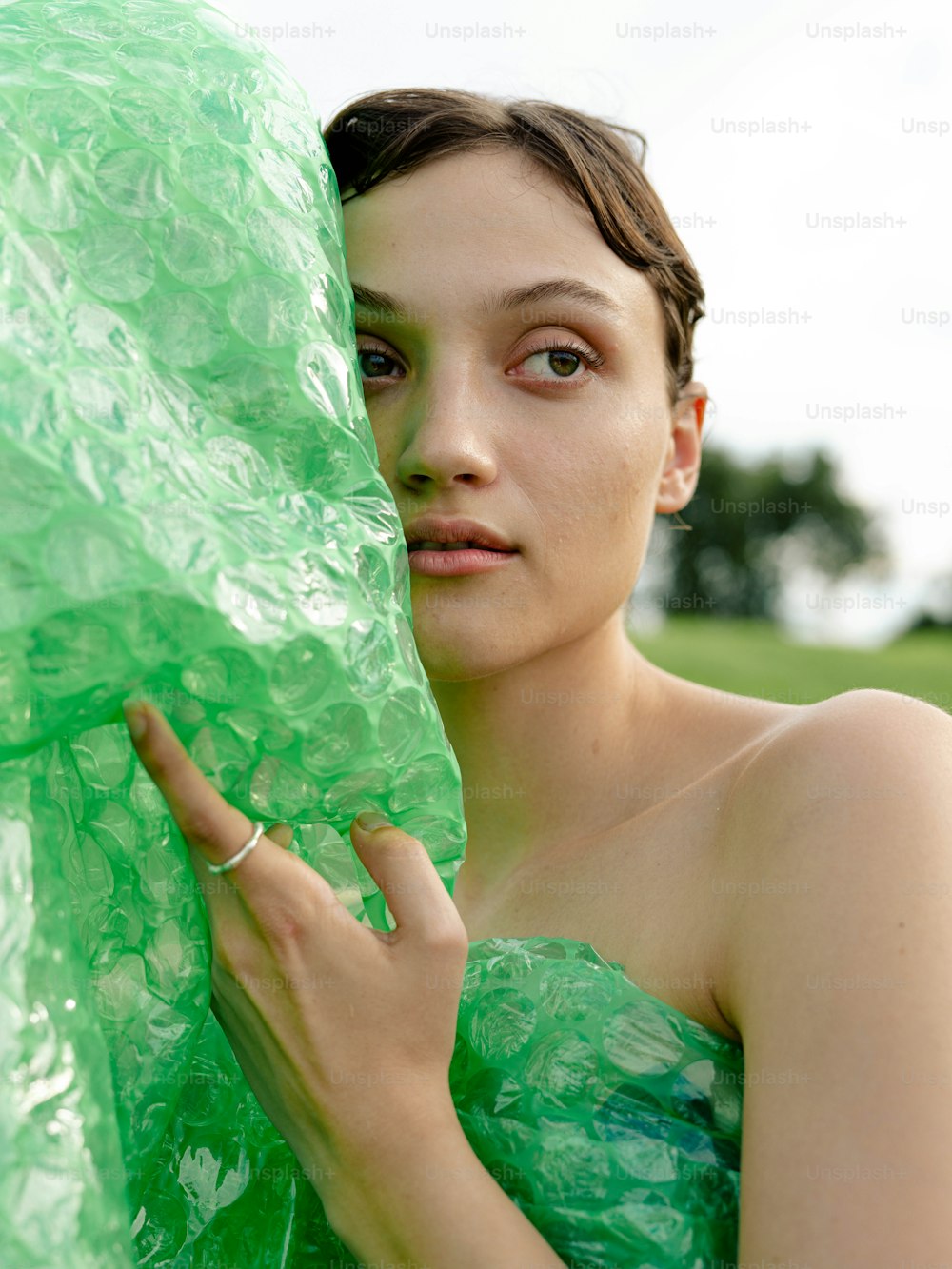 a woman in a green dress holding a plastic bag