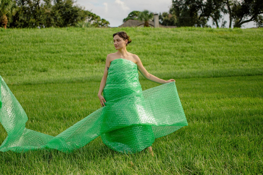 a woman in a green dress is walking in the grass