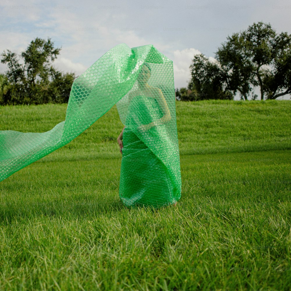 una persona in un campo con una sciarpa verde