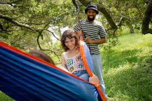 a man and a little girl sitting in a hammock
