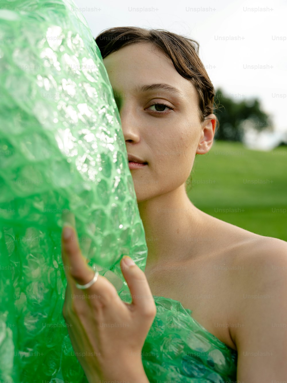 a woman in a green dress is holding a plastic bag