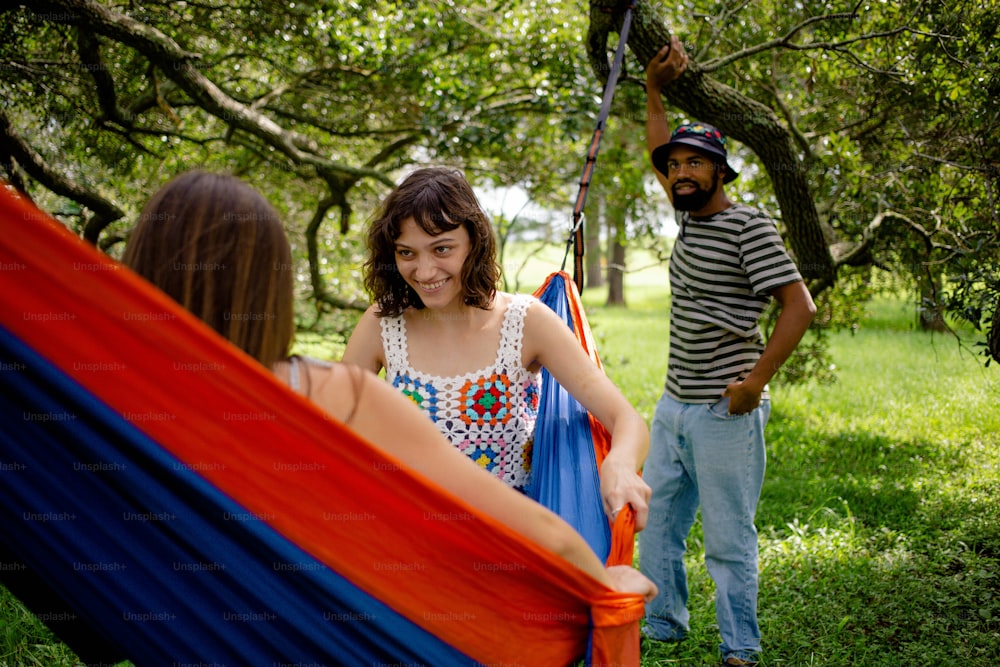 a woman in a hammock with a man standing behind her