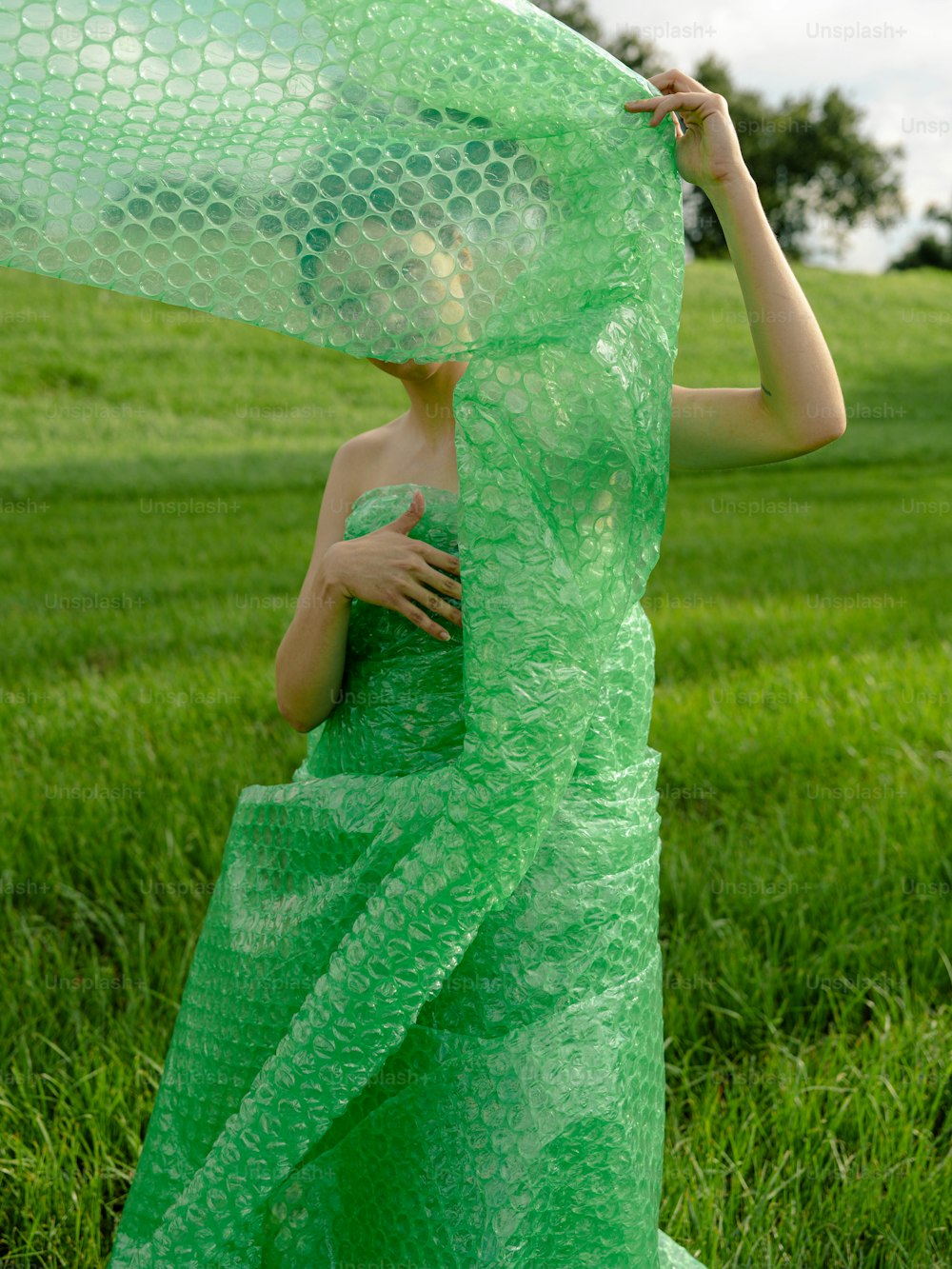 Eine Frau in einem grünen Kleid hält einen grünen Schal in der Hand