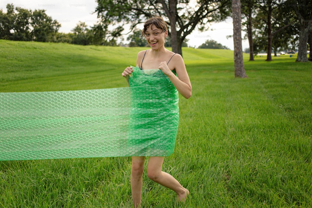Une femme en robe verte tenant un foulard vert