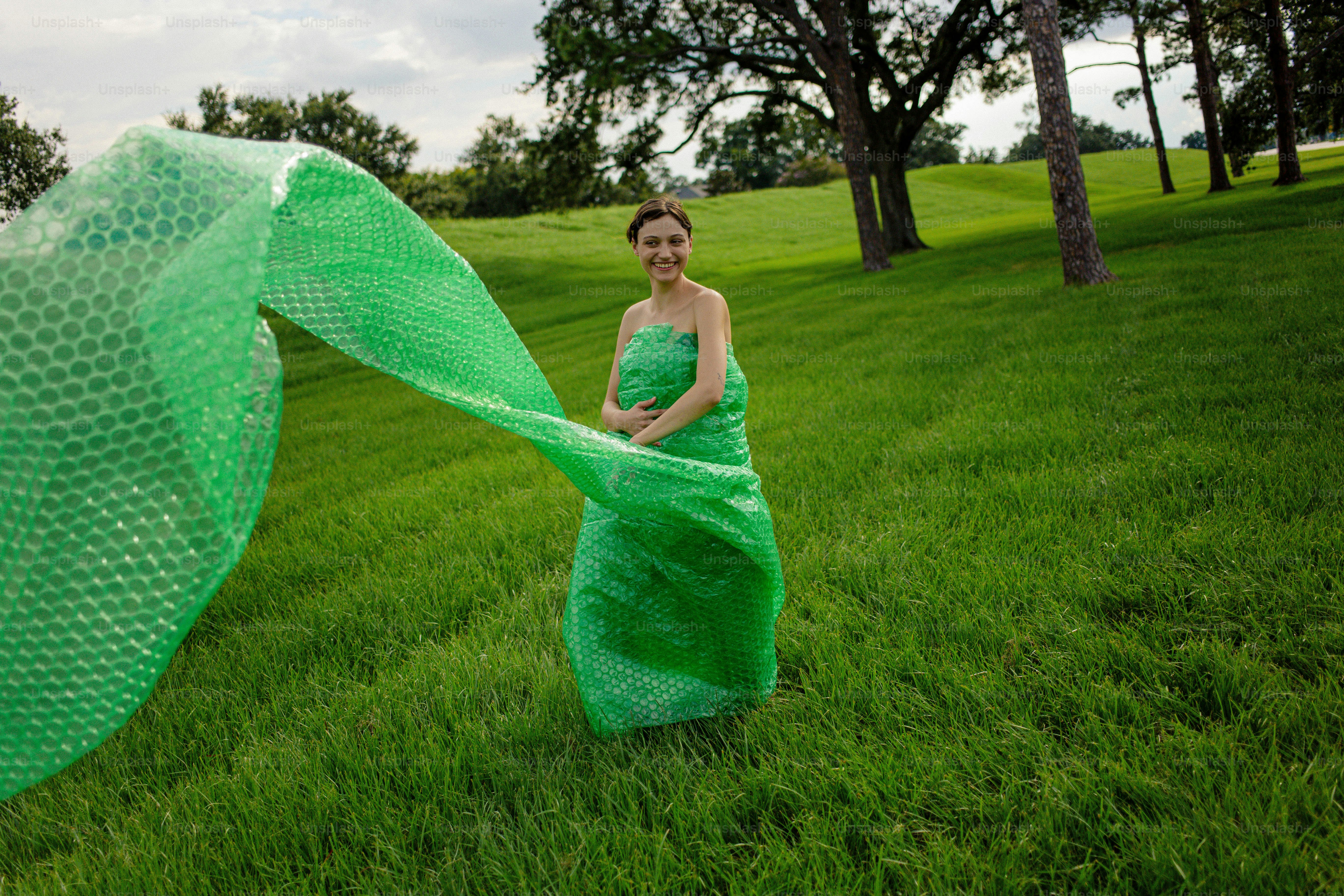 A woman in a green dress standing in a field photo – Dress Image on ...