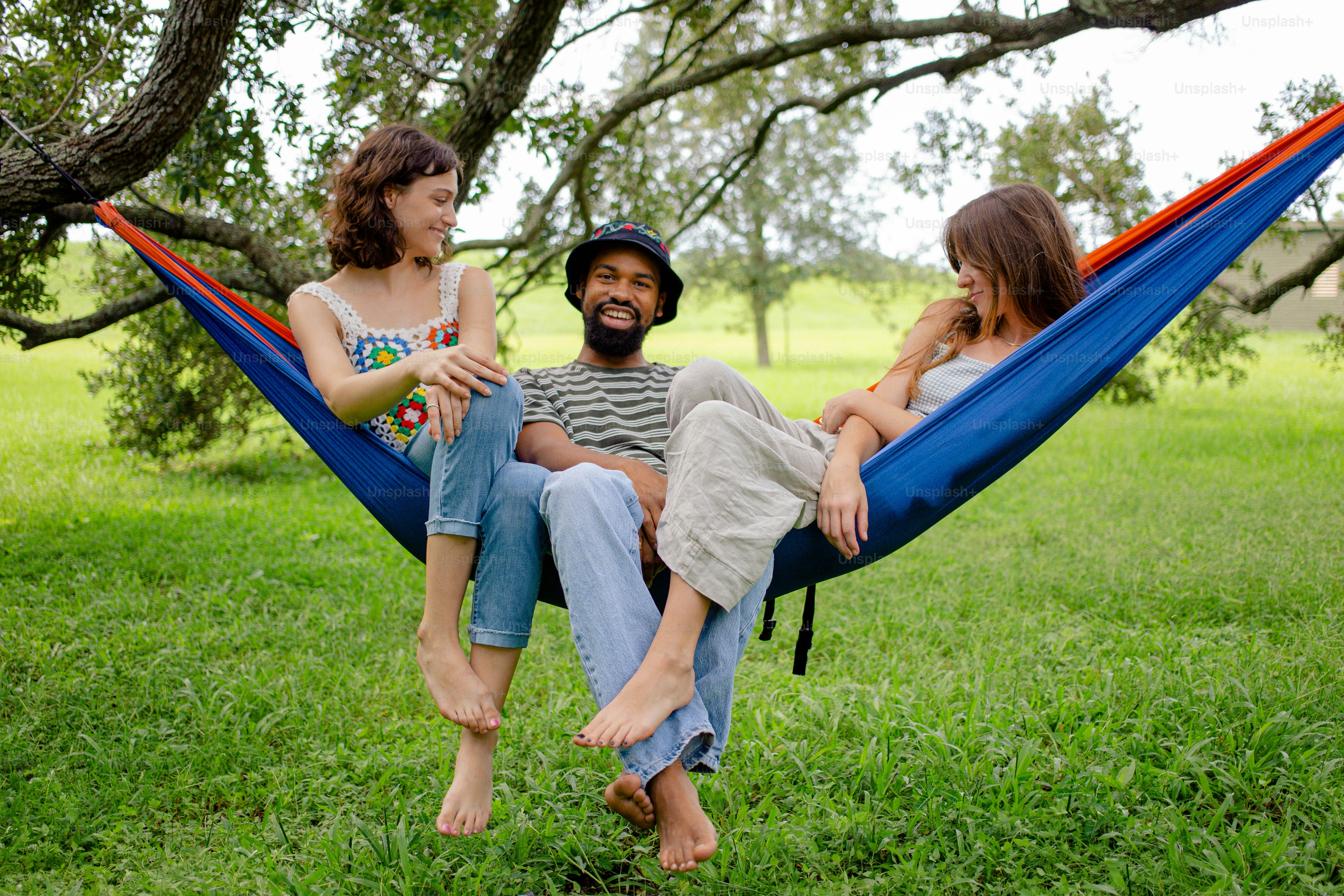a man and a woman sitting in a hammock