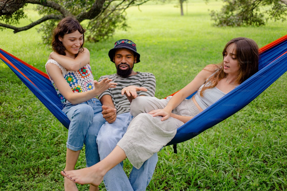 a man sitting in a hammock with two girls