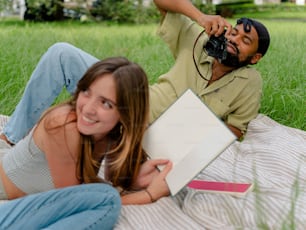 a man taking a picture of a woman laying on the grass