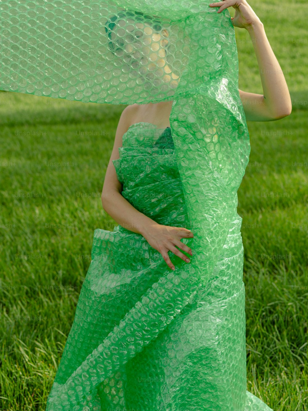 a woman in a green dress is holding a piece of plastic