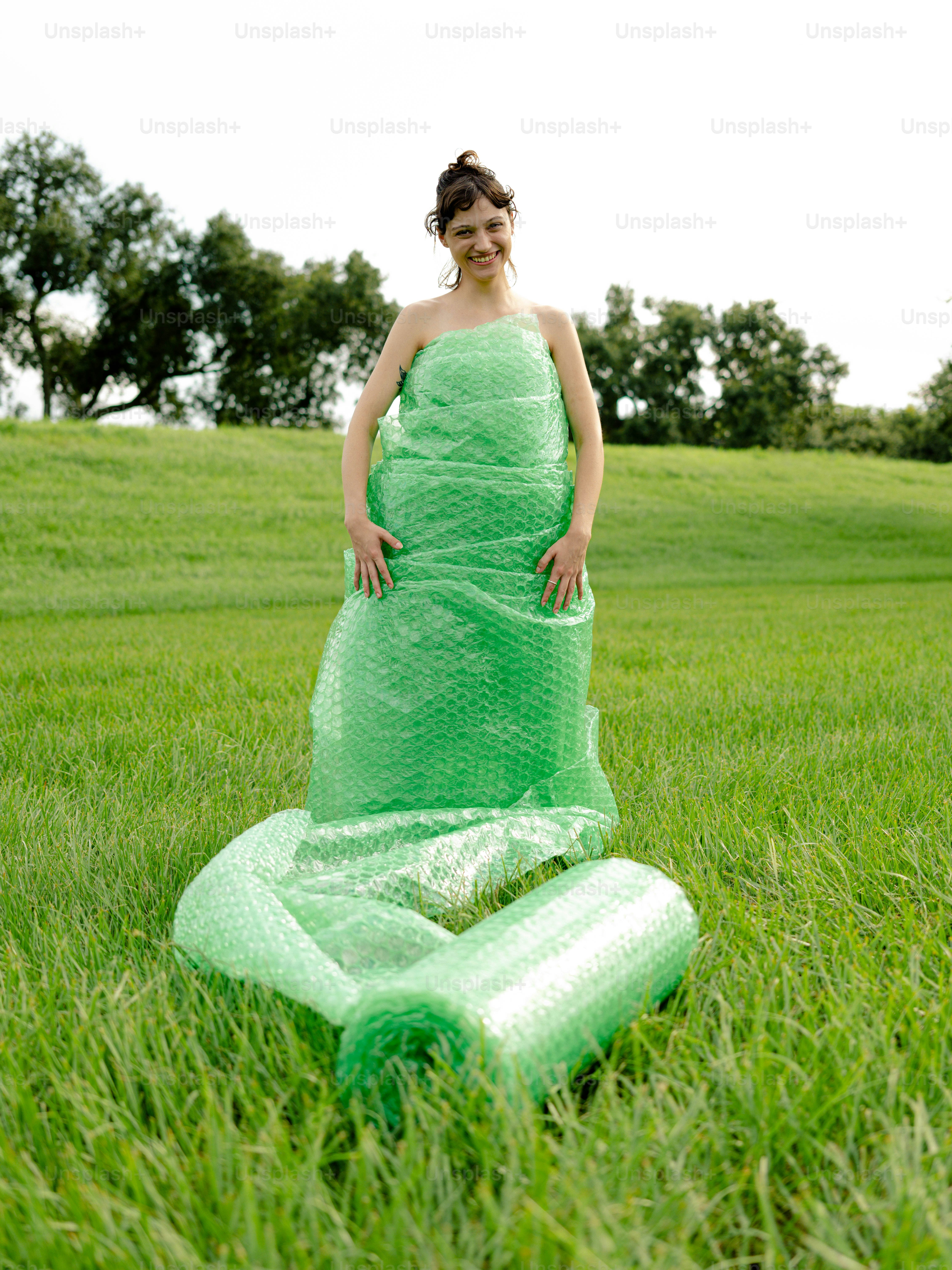 a woman in a green dress standing in a field