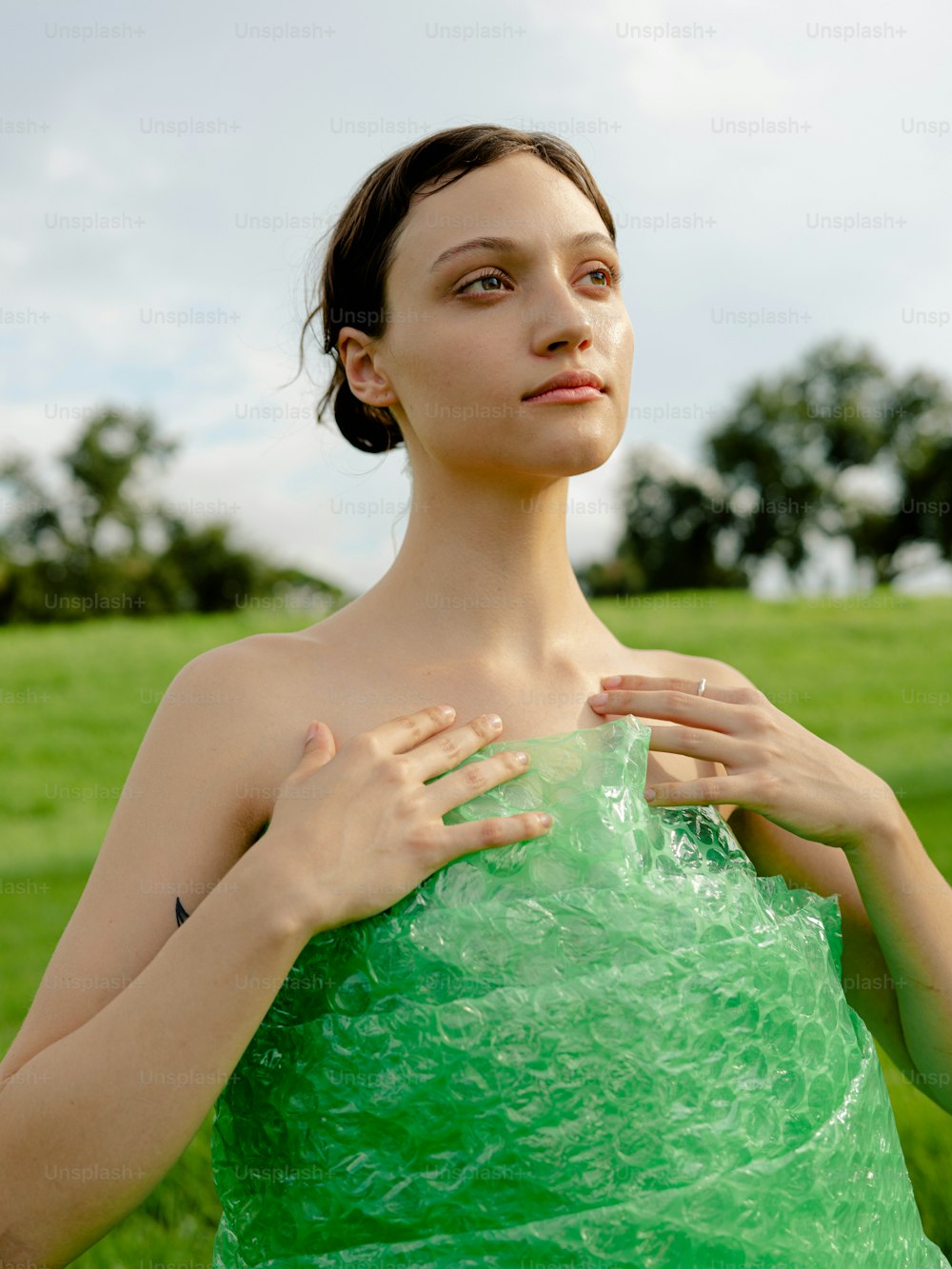 Eine Frau in einem grünen Kleid, die auf einem Feld steht