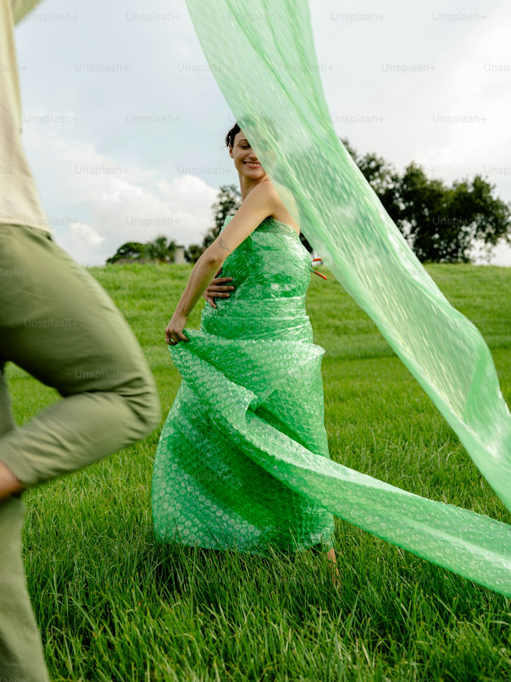 a woman in a green dress holding a green scarf