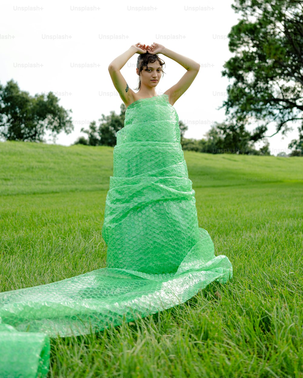 草むらに座る緑のドレスを着た女性