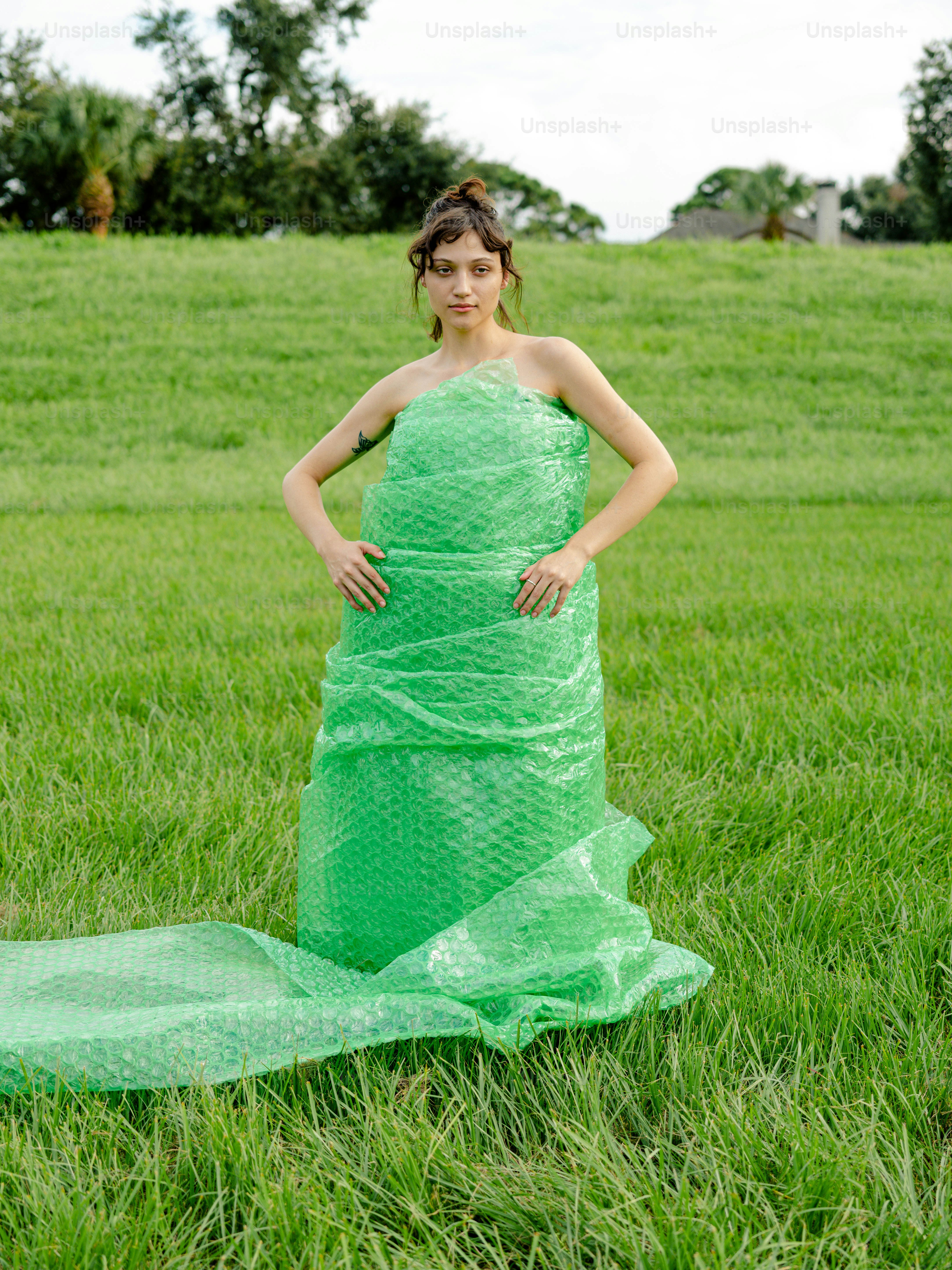 a woman in a green dress standing in a field