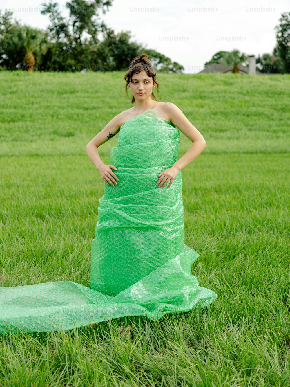 Eine Frau in einem grünen Kleid, die auf einem Feld steht