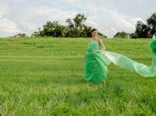 a woman in a green dress standing in a field