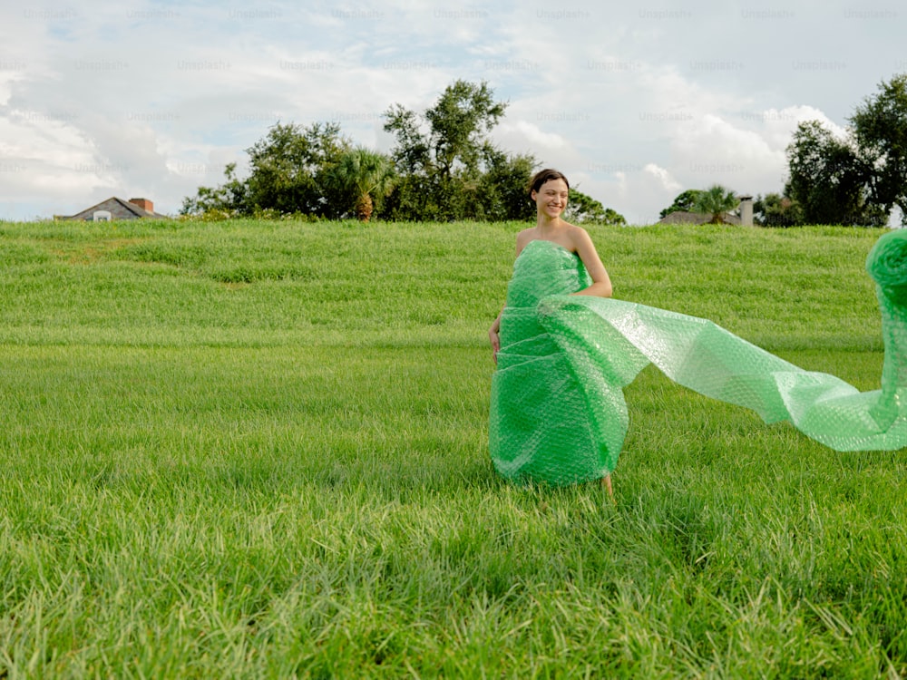 a woman in a green dress standing in a field