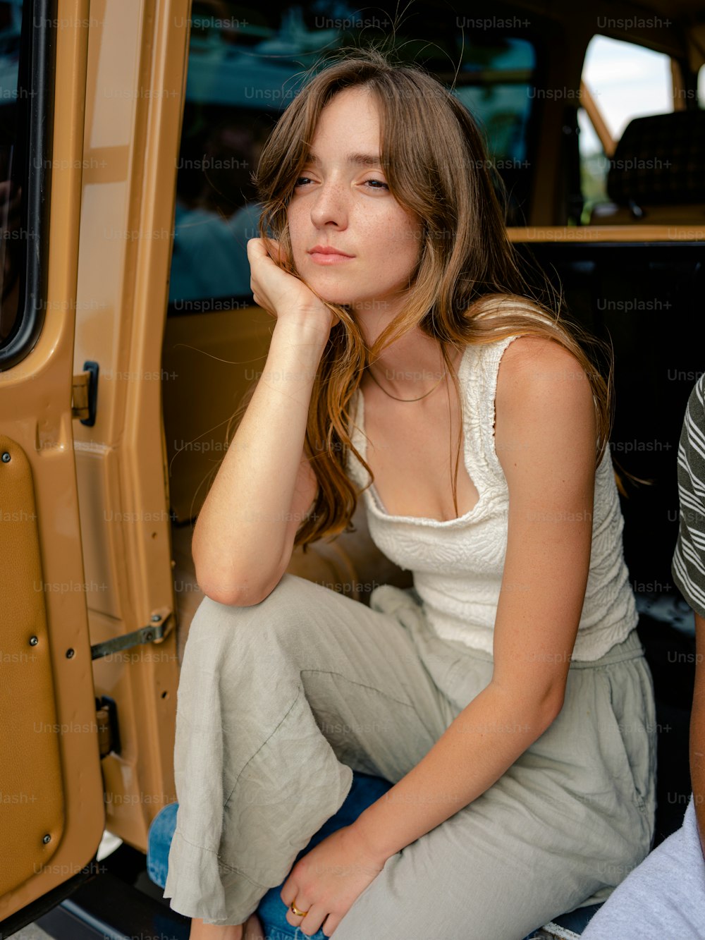 a woman sitting in the back of a vehicle