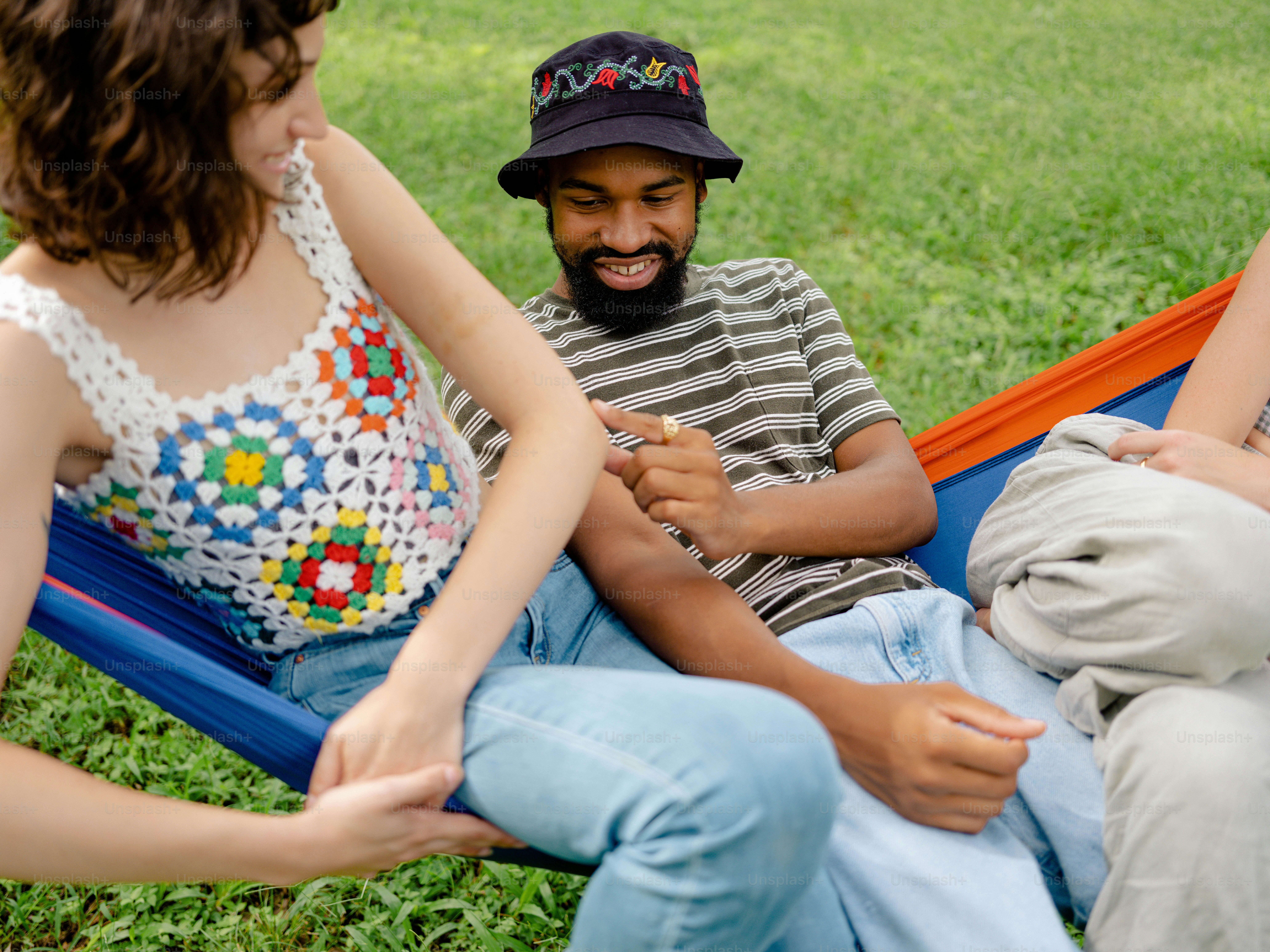 2人の女性と一緒にハンモックに座っている男性