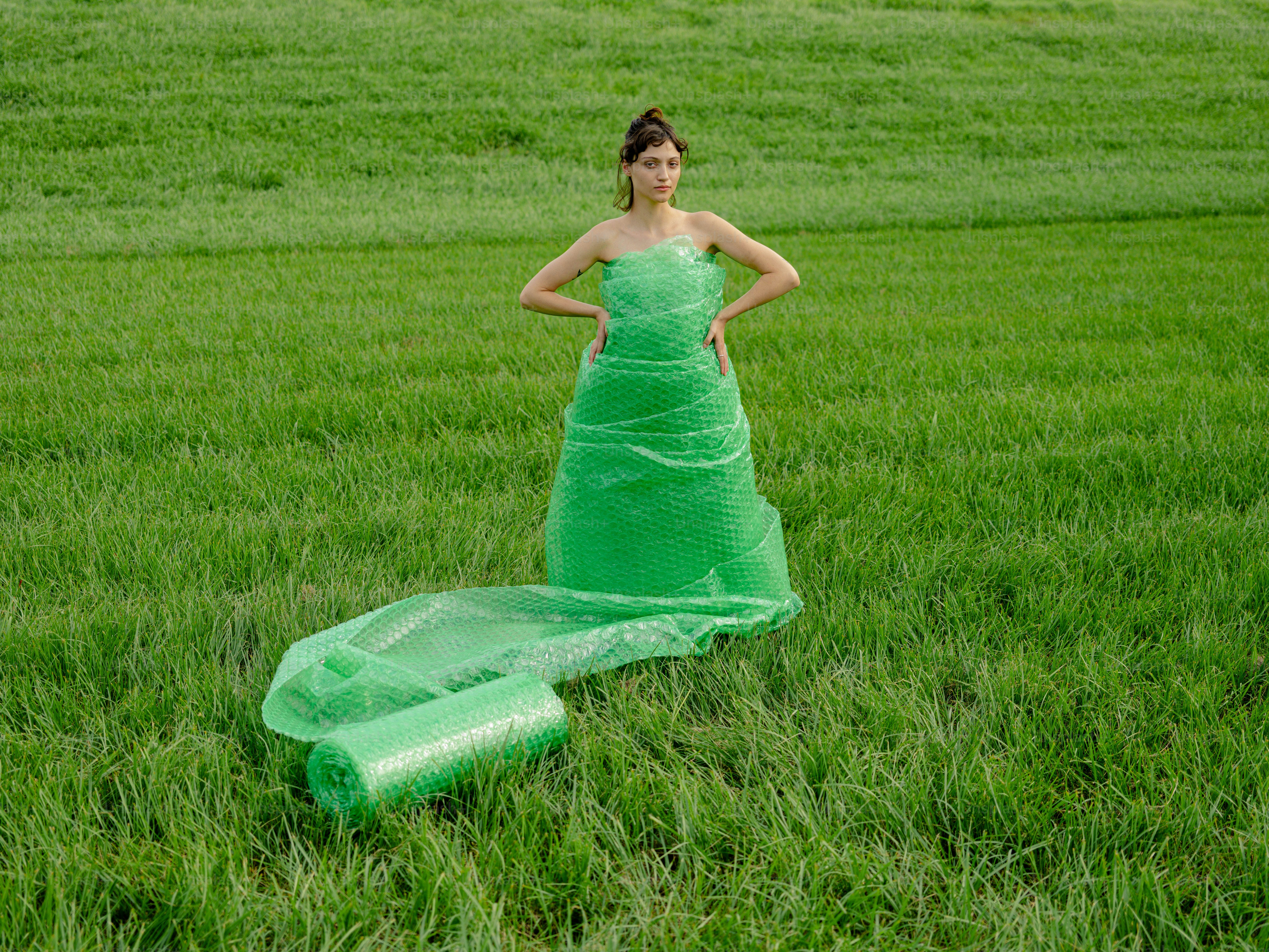 a woman in a green dress standing in a field