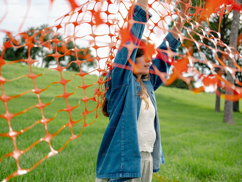 a woman holding up a kite in a field