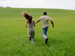 a man and a woman running through a field