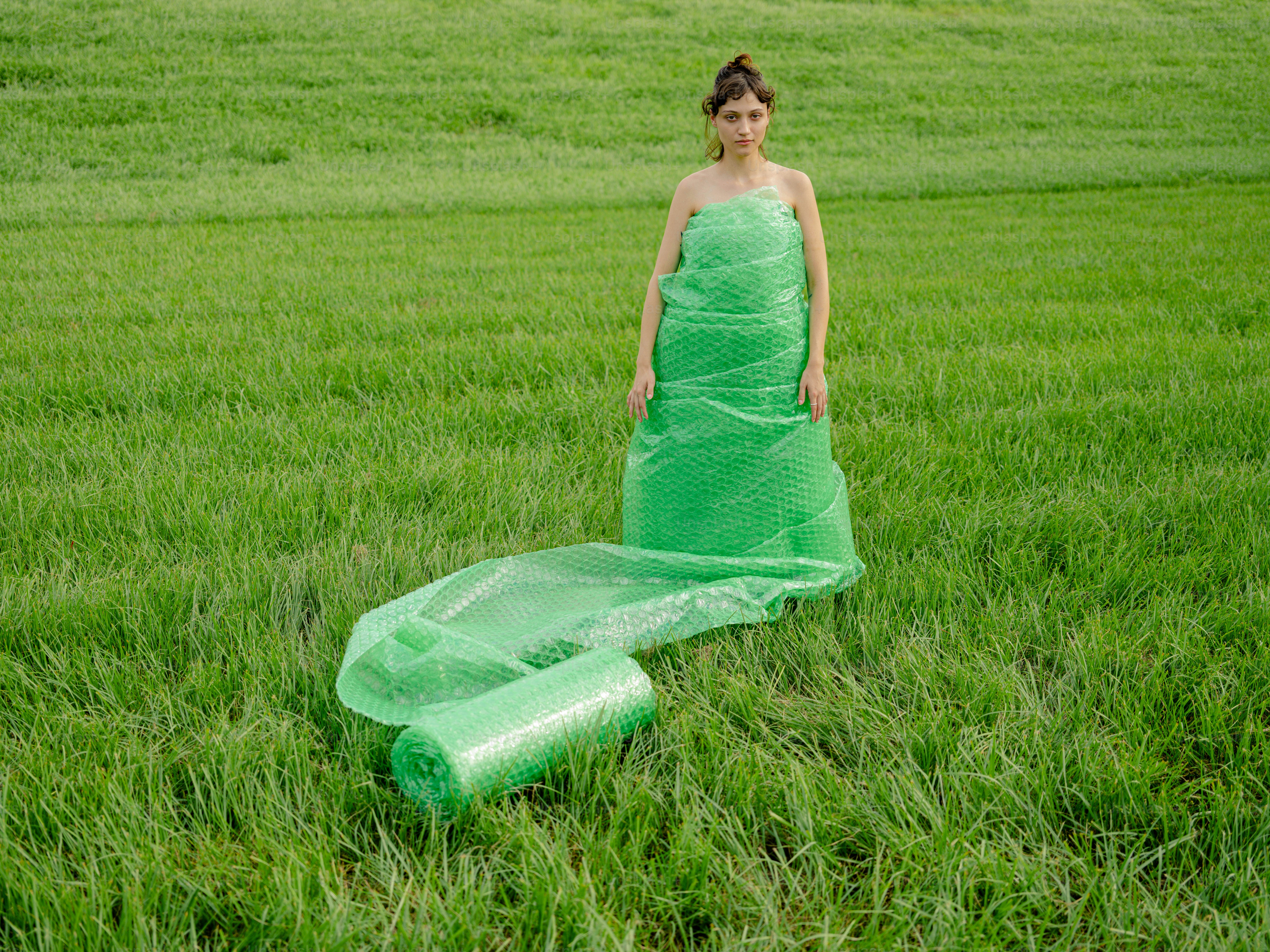 A woman in a green dress standing in a field photo – Portrait Image on ...