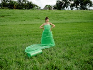 Una mujer con un vestido verde parada en un campo
