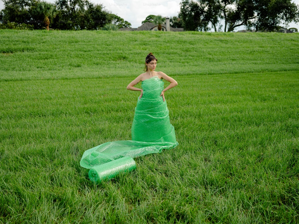 野原に立つ緑のドレスを着た女性